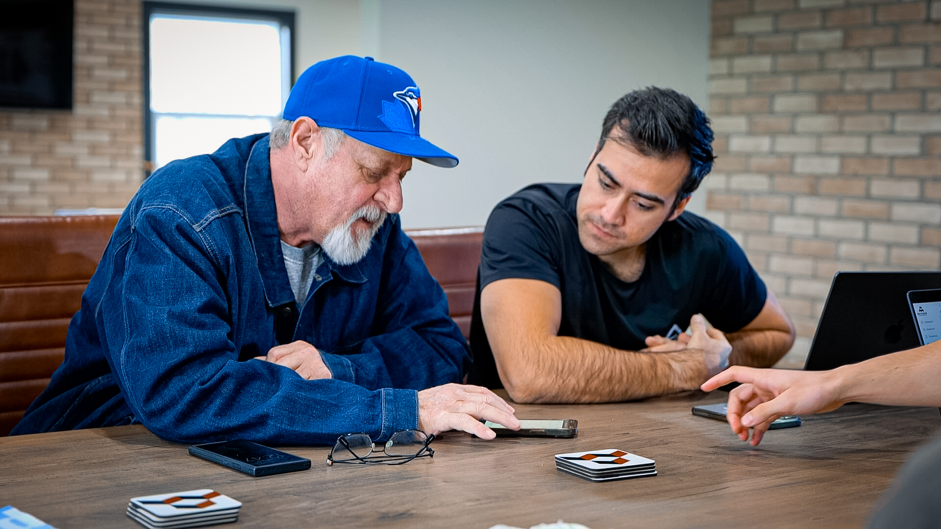 Two people reviewing a phone together at a conference table
