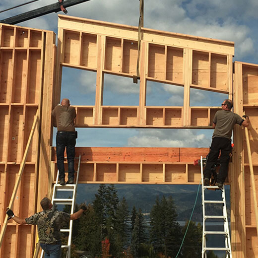 Panelized wall sections lifted by crane into place